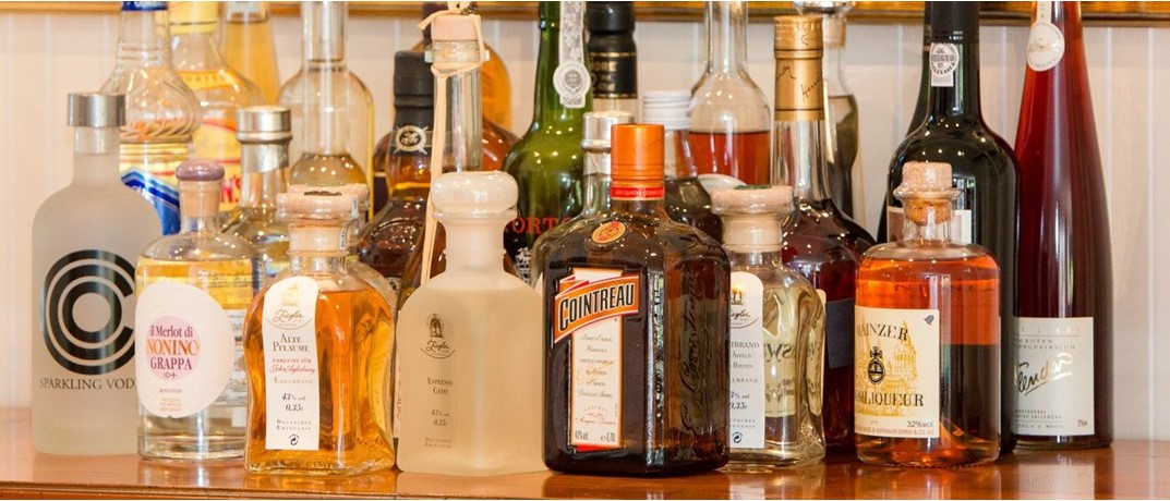 Gin Flaschen richtig gelagert im dunklen Schrank ohne Lichteinfall