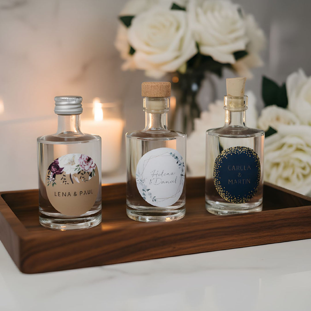 Personalisiertes Gastgeschenk zur Hochzeit: 50ml Spirituosen-Mini mit  Etiketten der kartenmacherei.de auf einer festlichen Tafel.